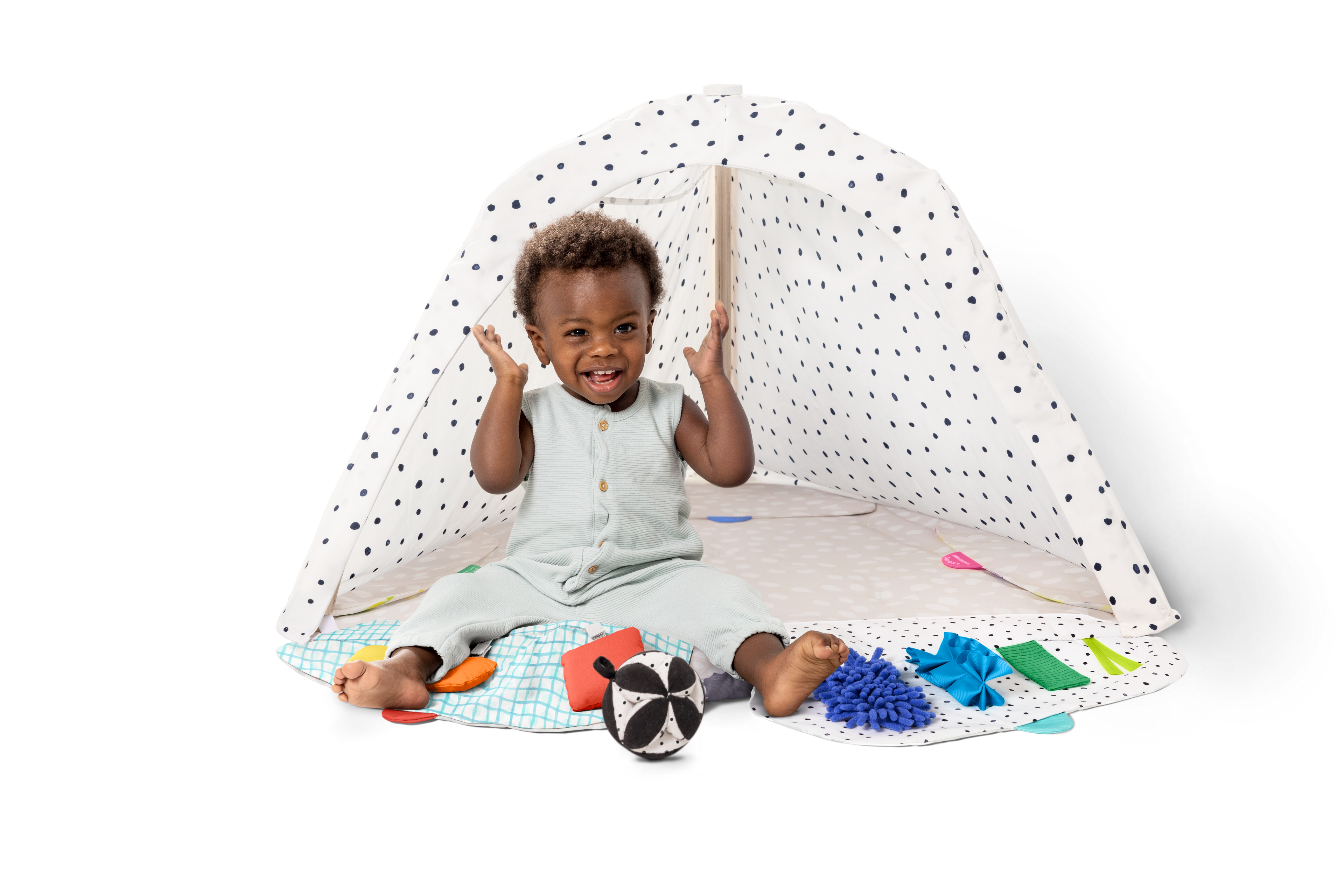 Child playing with toys on a white floor with a white canopy in the background