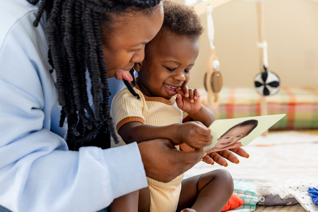 Woman and child reading a book together in a cozy living room.