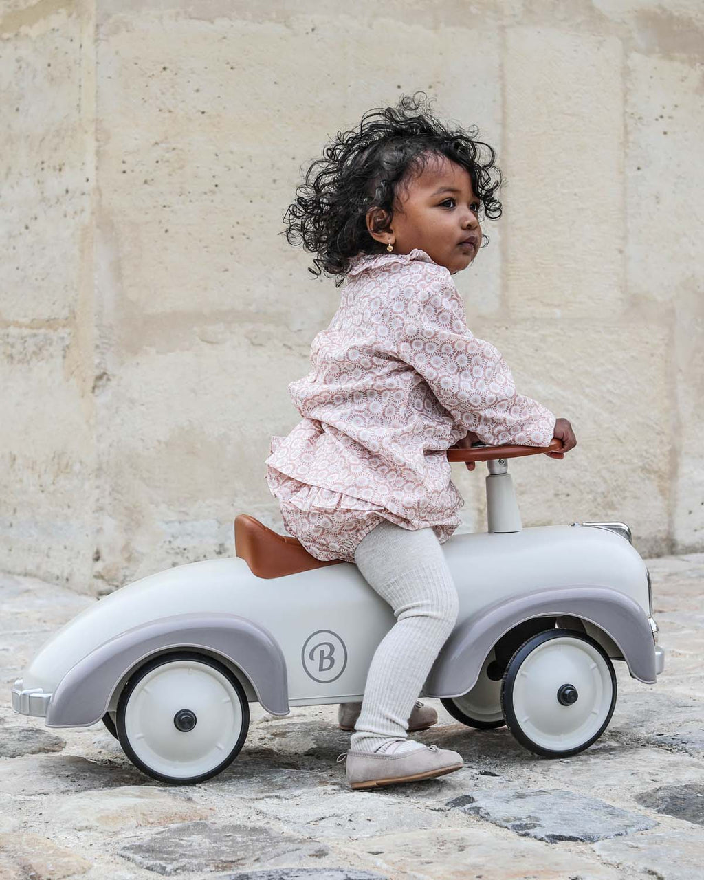 Cream  vintage style baghera ride-on speedster on a white background