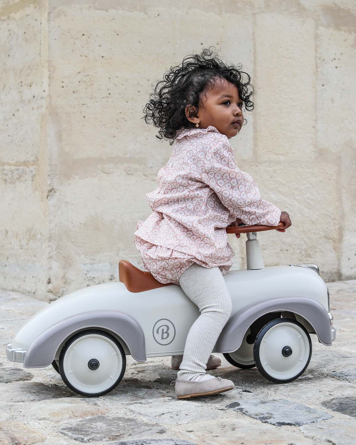 Cream  vintage style baghera ride-on speedster on a white background