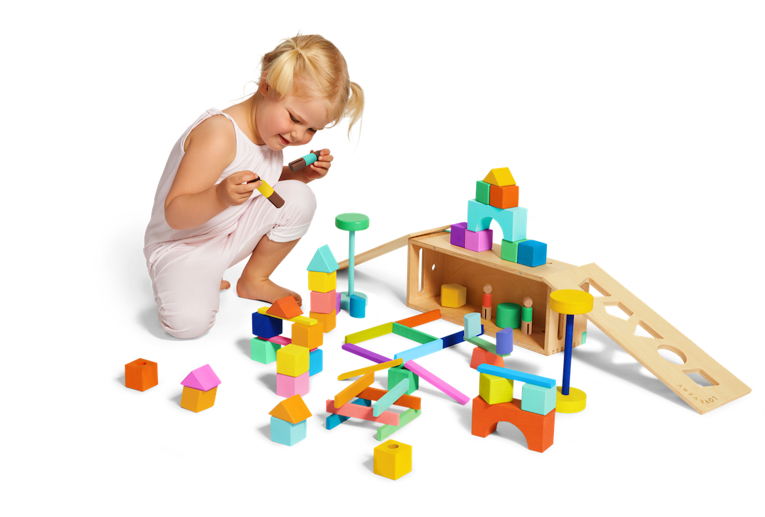 Child playing with colorful wooden building blocks on a white background