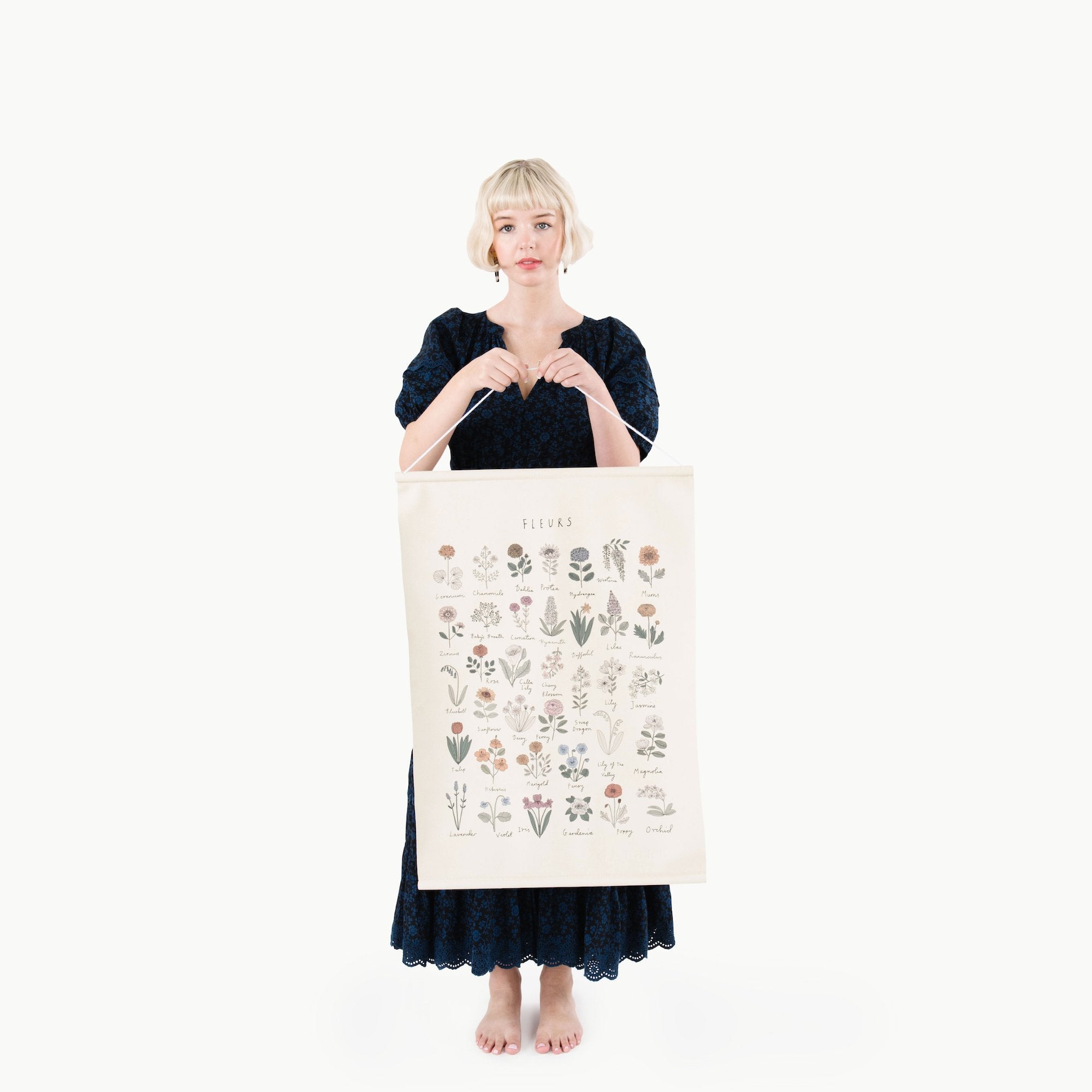 Woman holding a large tote bag with plant illustrations on a white background
