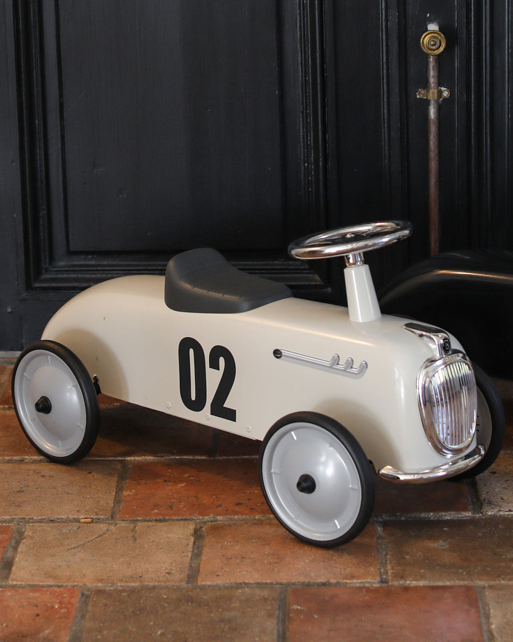 White baghera ride-on toy car with number 02 on a tiled floor