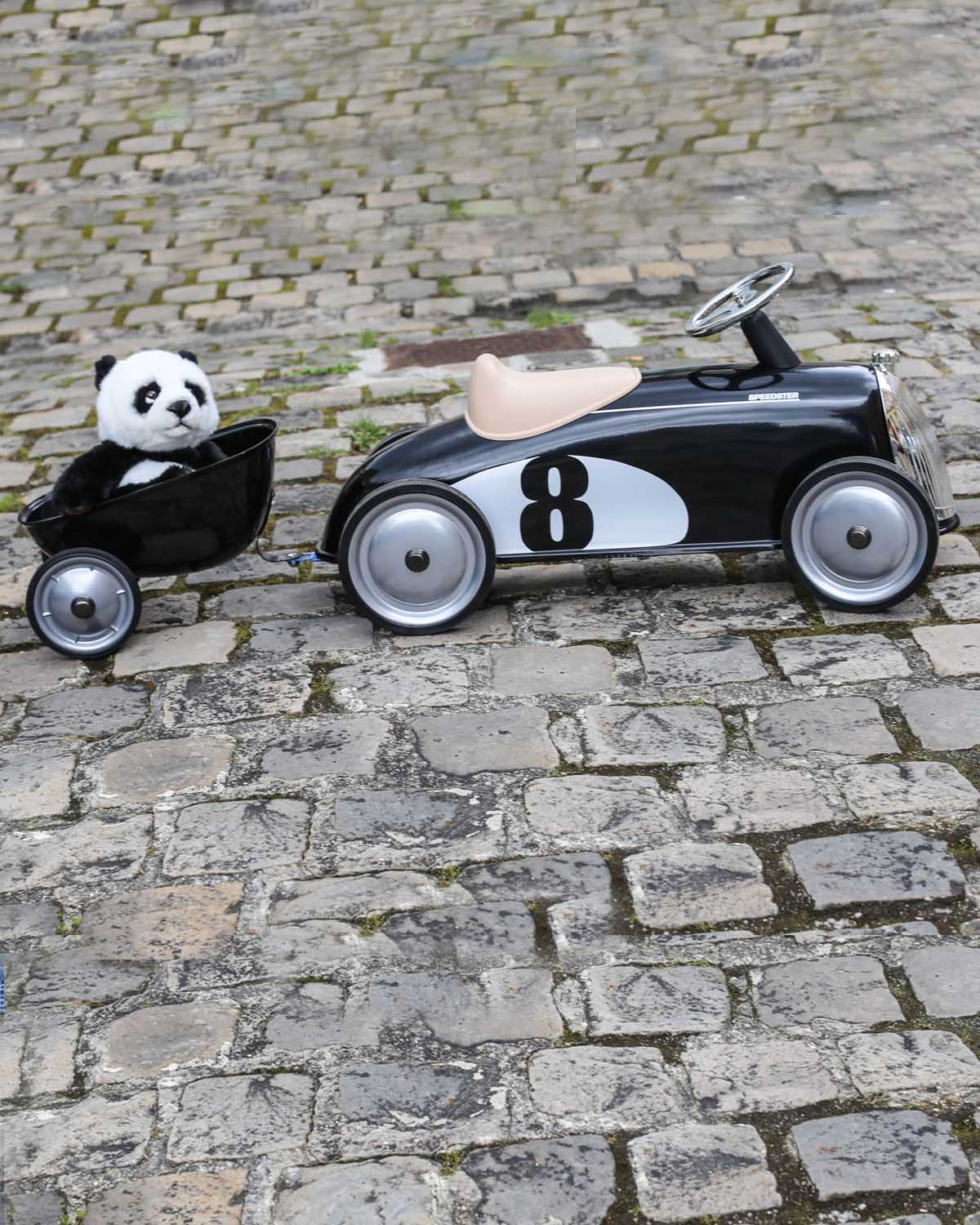 Children's toy car with number 8 and panda bear on a cobblestone surface